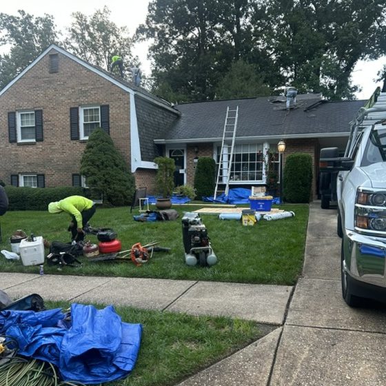 Tools and equipment staged on a lawn during a roof replacement